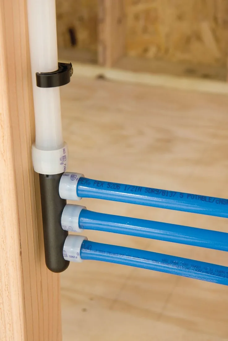 Blue PEX lines leaving a manifold fastened to a wall stud, from our Newport Beach guide: Newport Beach Navien Tankless Water Heater Installation